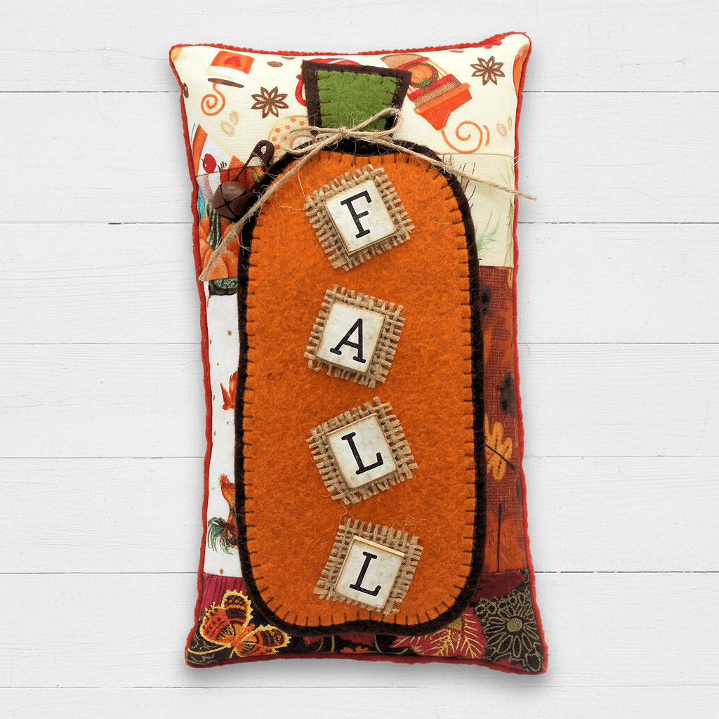 Autumn pillow tuck with a pumpkin and wooden tile letters reading 'F-A-L-L'