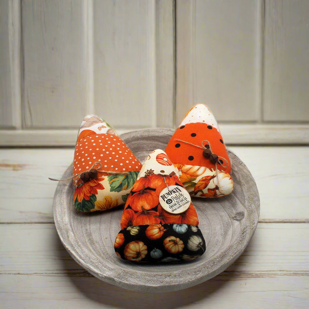Set of three colorful candy corn bowl fillers on plate on a shelf