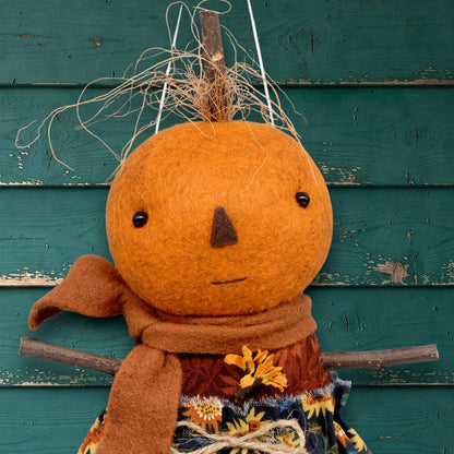 Pumpkin character doll in a sunflower skirt