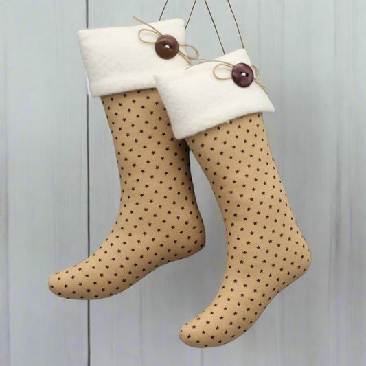 pair of Christmas stocking ornaments with tiny burgundy stars on a tan background with white fleece cuffs