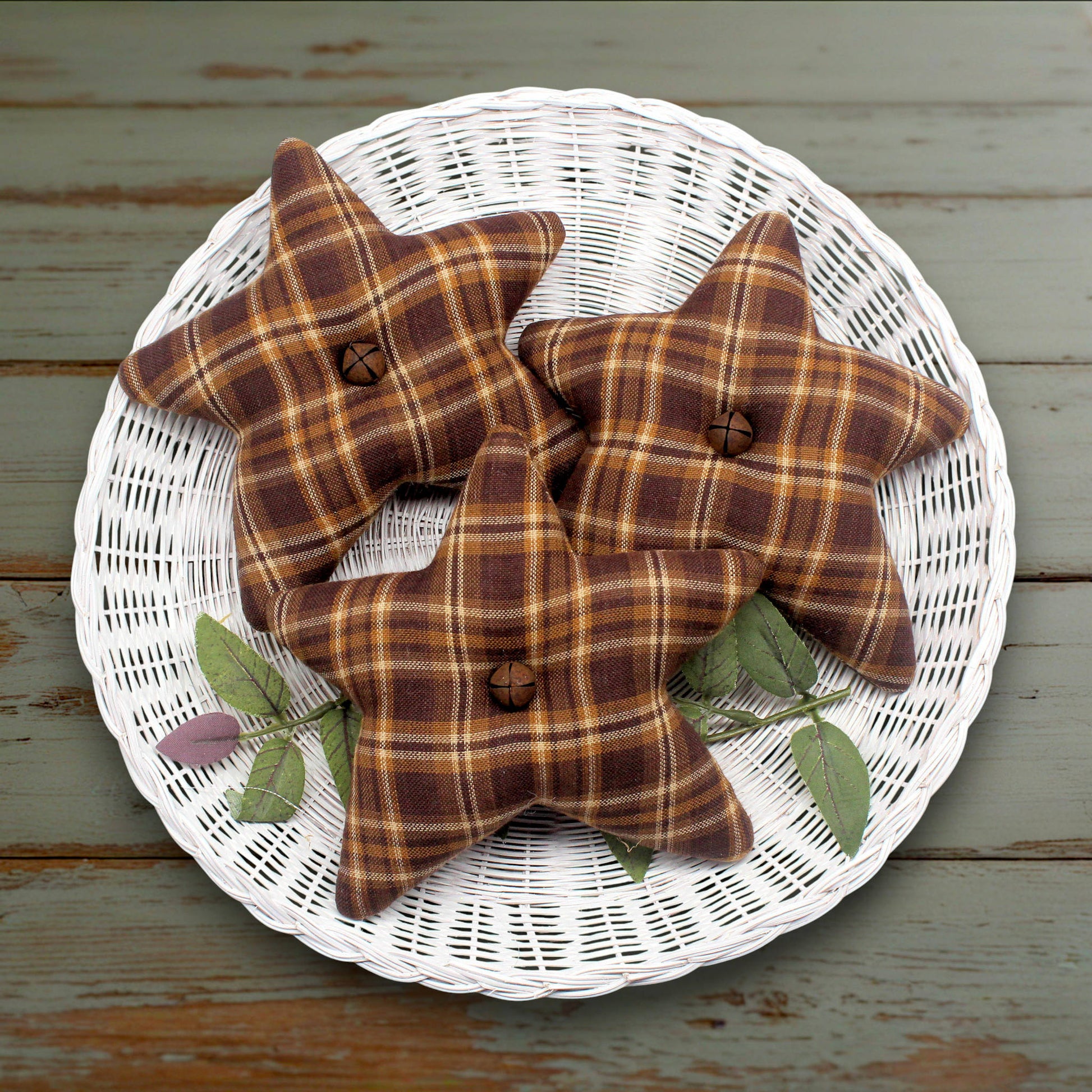 Set of three fabric homespun stars in brown, gold and tan with rusty bells in the centers