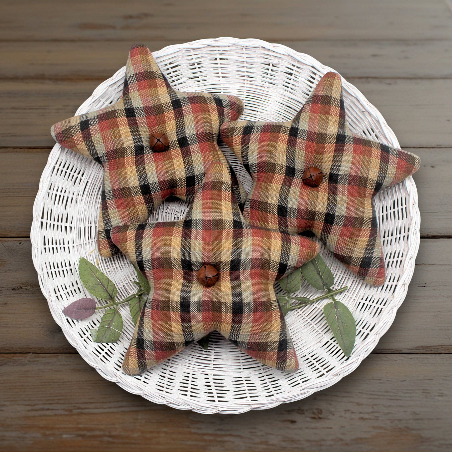 Set of three homespun stars made from brown, rust and tan fabric with rusty bells in the centers