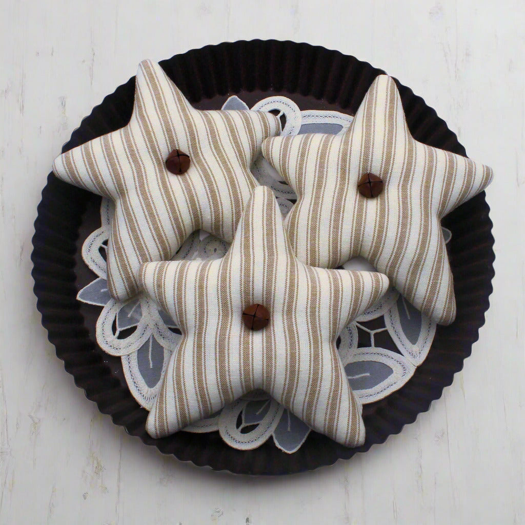 Set of three tan and eggshell homespun star bowl fillers with rusty bells