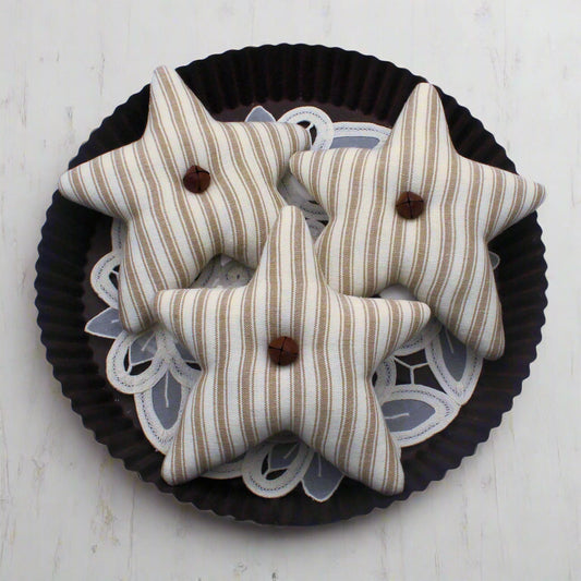 Set of three tan and eggshell homespun star bowl fillers with rusty bells