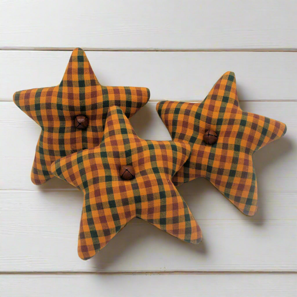 Three star-shaped buttons with orange, green, and brown plaid pattern on a white background