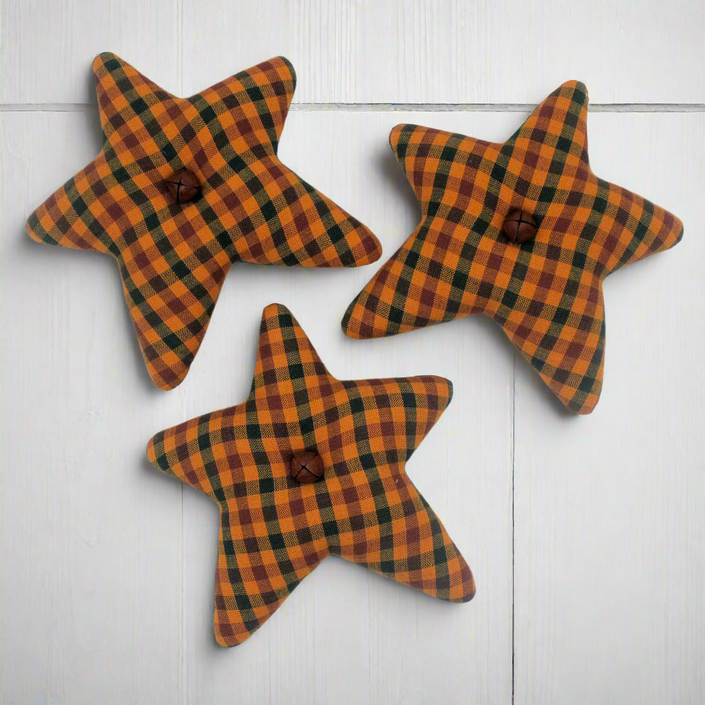 Three star-shaped decorations with orange plaid pattern on a white background