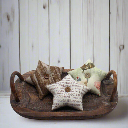 Three decorative farmhouse star bowl fillers on a wooden tray with a rustic background