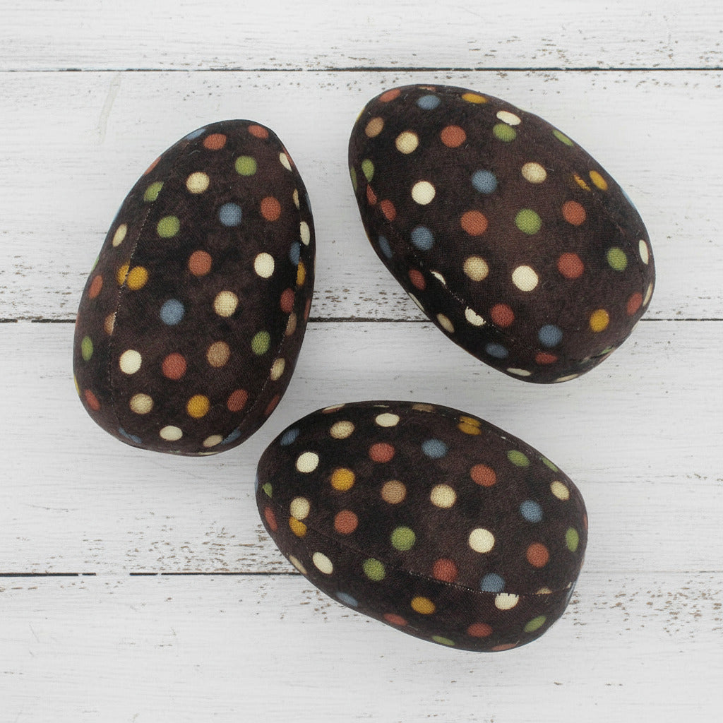 Three polka-dotted fabric egg bowl fillers on a white background