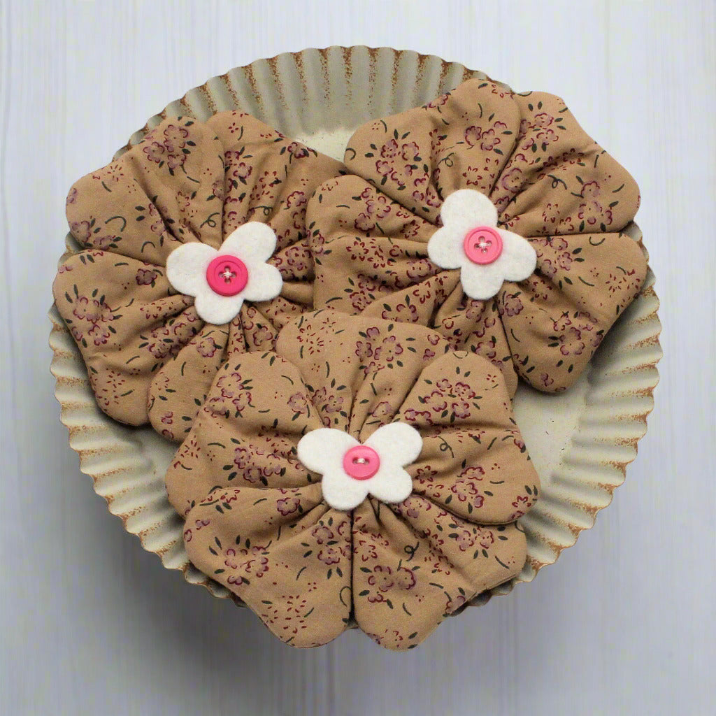 Flower bowl fillers with floral patterns and white flowers with pink centers on a white background