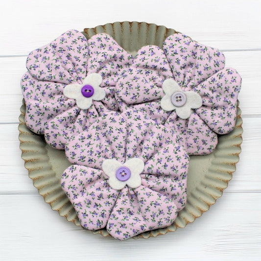 Floral fabric flowers with buttons on a metal tray