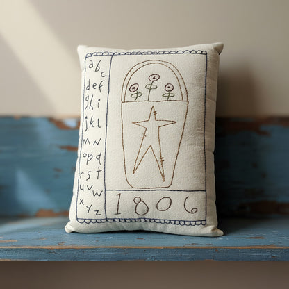 Hand-stitched decorative pillow with a primitive sampler and basket design