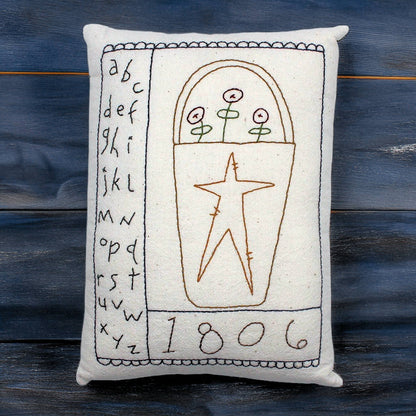 Hand-stitched decorative pillow with a primitive basket and alphabet design