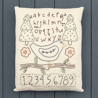 Hand-stitched decorative pillow with a bluebird sampler design