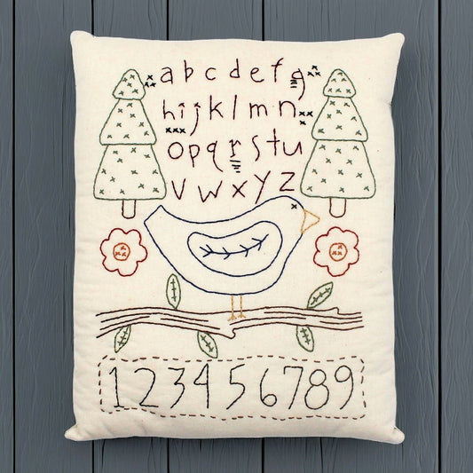 Hand-stitched decorative pillow with a bluebird sampler design