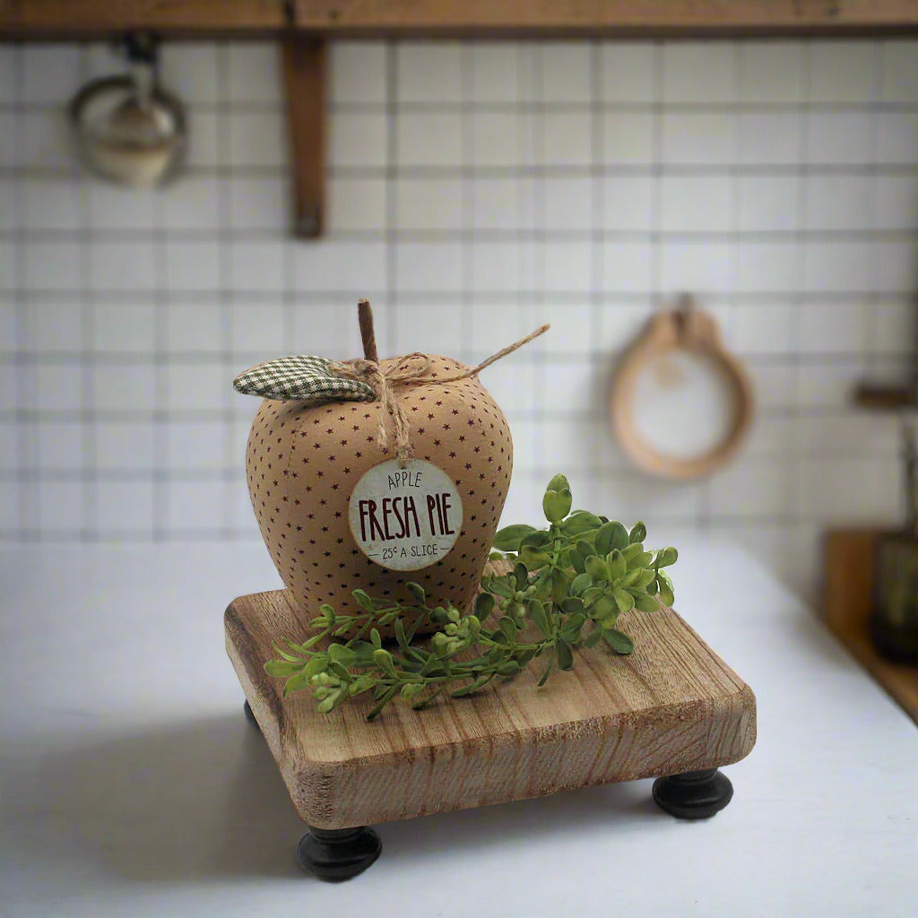 Decorative apple with a label on a wooden base