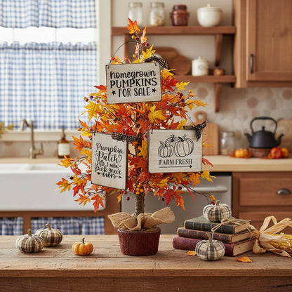 Decorative fall arrangement with pumpkins, books, and signs on a kitchen counter.