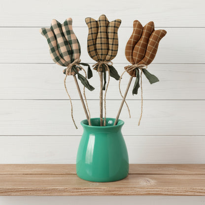 Three homespun tulips in a green vase on a white background