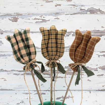 Three homespun fabric tulips tied with twine on a rustic wooden background