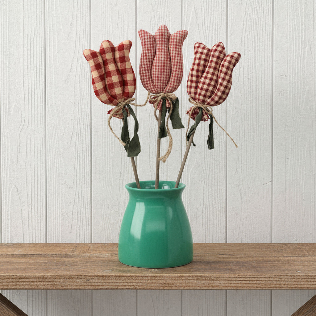 Three checkered tulip-shaped objects in a green vase on a white background