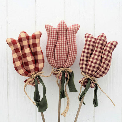 Three fabric tulips with checkered pattern on a white wooden background