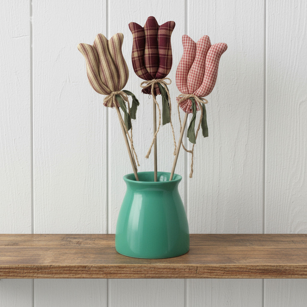 Three fabric tulips in a green vase on a white background
