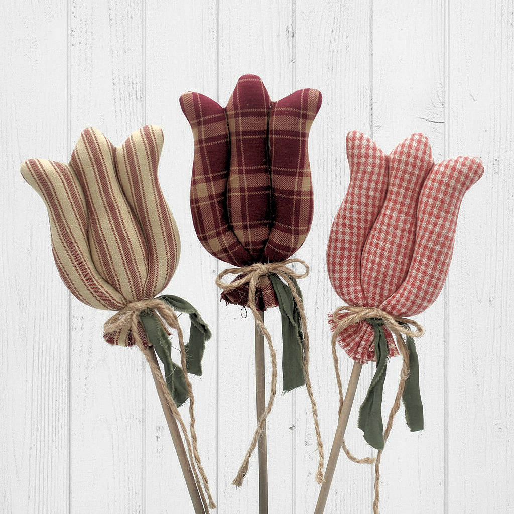 Three fabric tulips in plaid, striped, and checkered patterns on a wooden background.