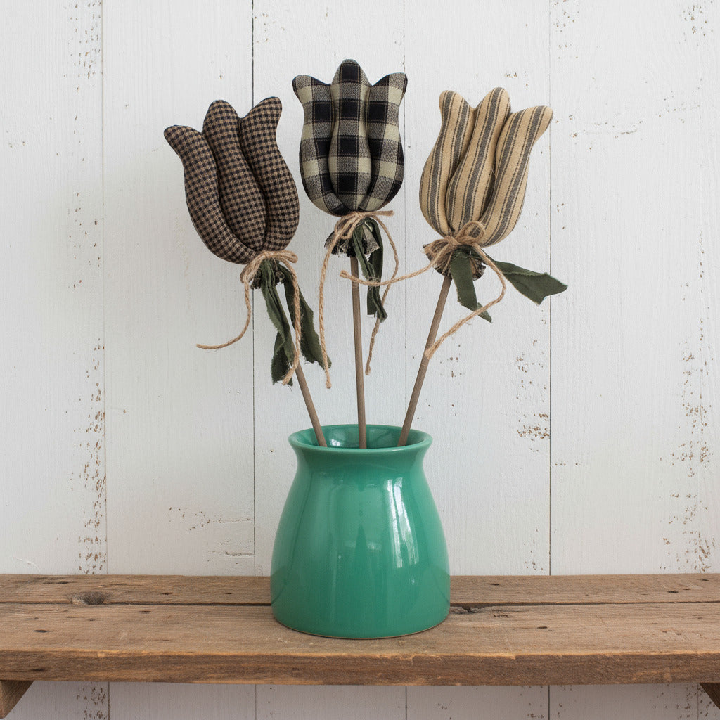 Three fabric tulips in a green vase on a white background