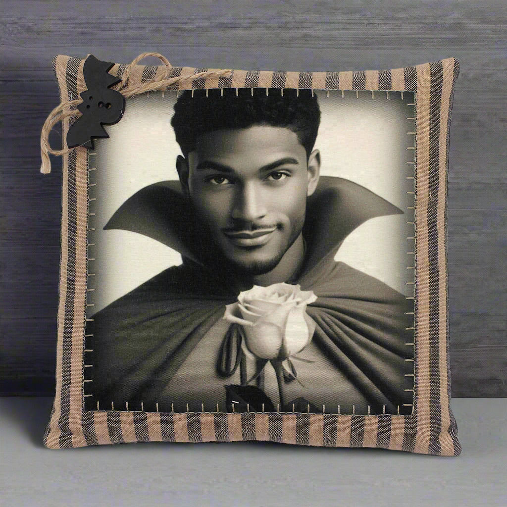 Decorative pillow with a black and white portrait of a handsome young vampire holding a rose, framed by a striped border.