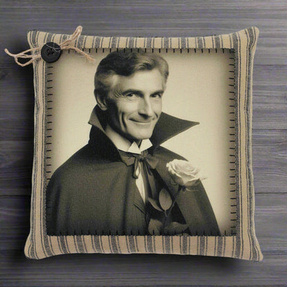 Pillow with a vintage-style portrait of a handsome vampire in a dark coat and cape holding a rose, framed by striped fabric.