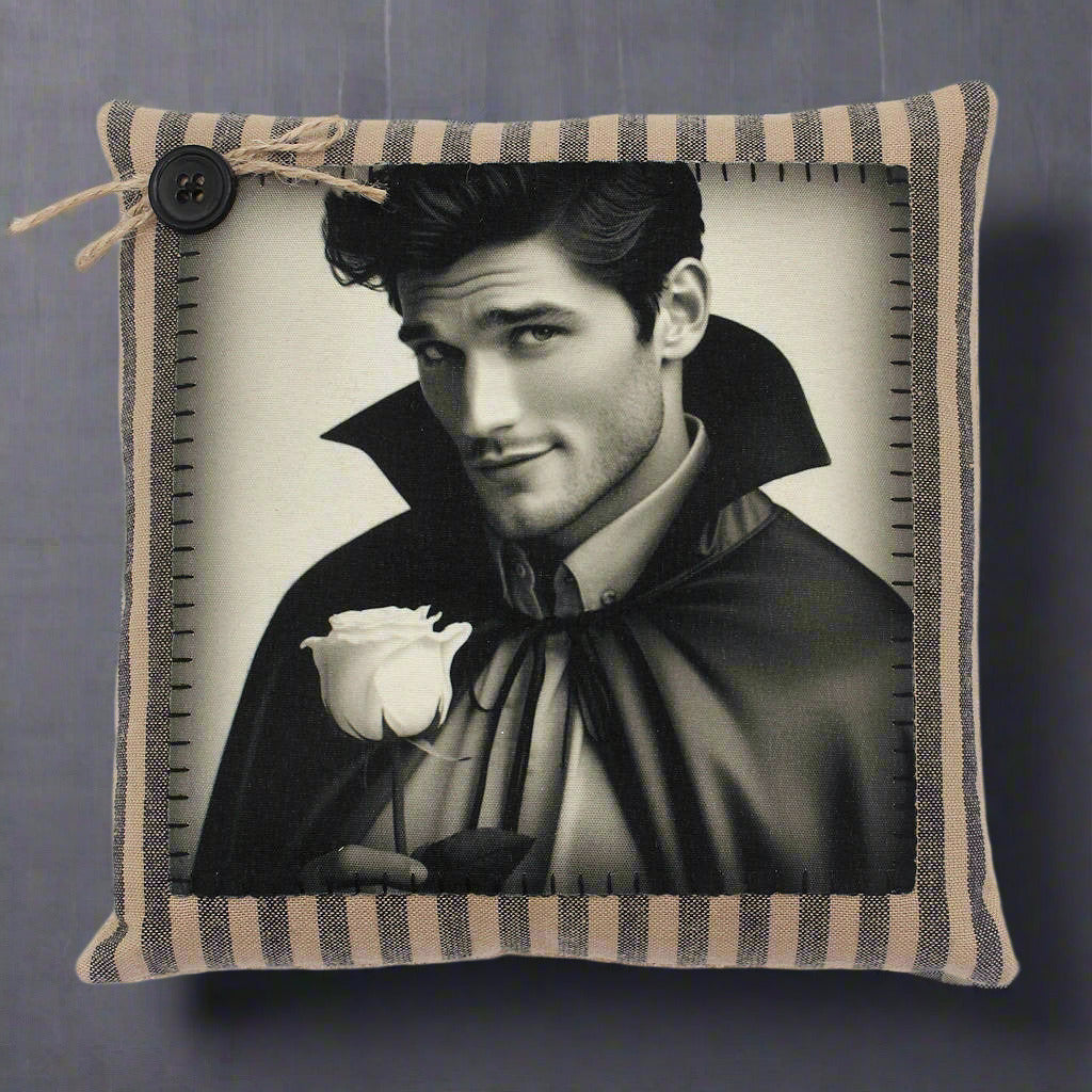Decorative pillow with a black and white portrait of a handsome young vampire holding a rose, framed by a striped border.