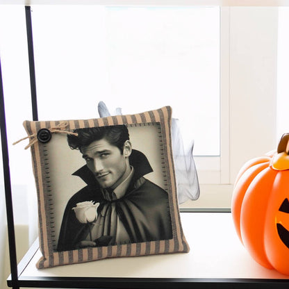 Decorative pillow with a black and white image of a handsome young vampire in a costume, next to a small pumpkin.