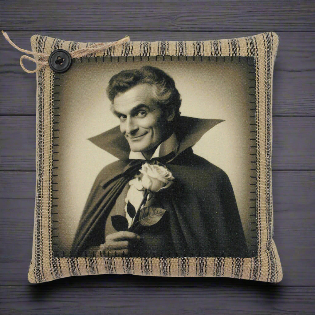 Decorative pillow with a vintage-style portrait of a handsome vampire in dark cape holding a rose, framed by striped fabric.