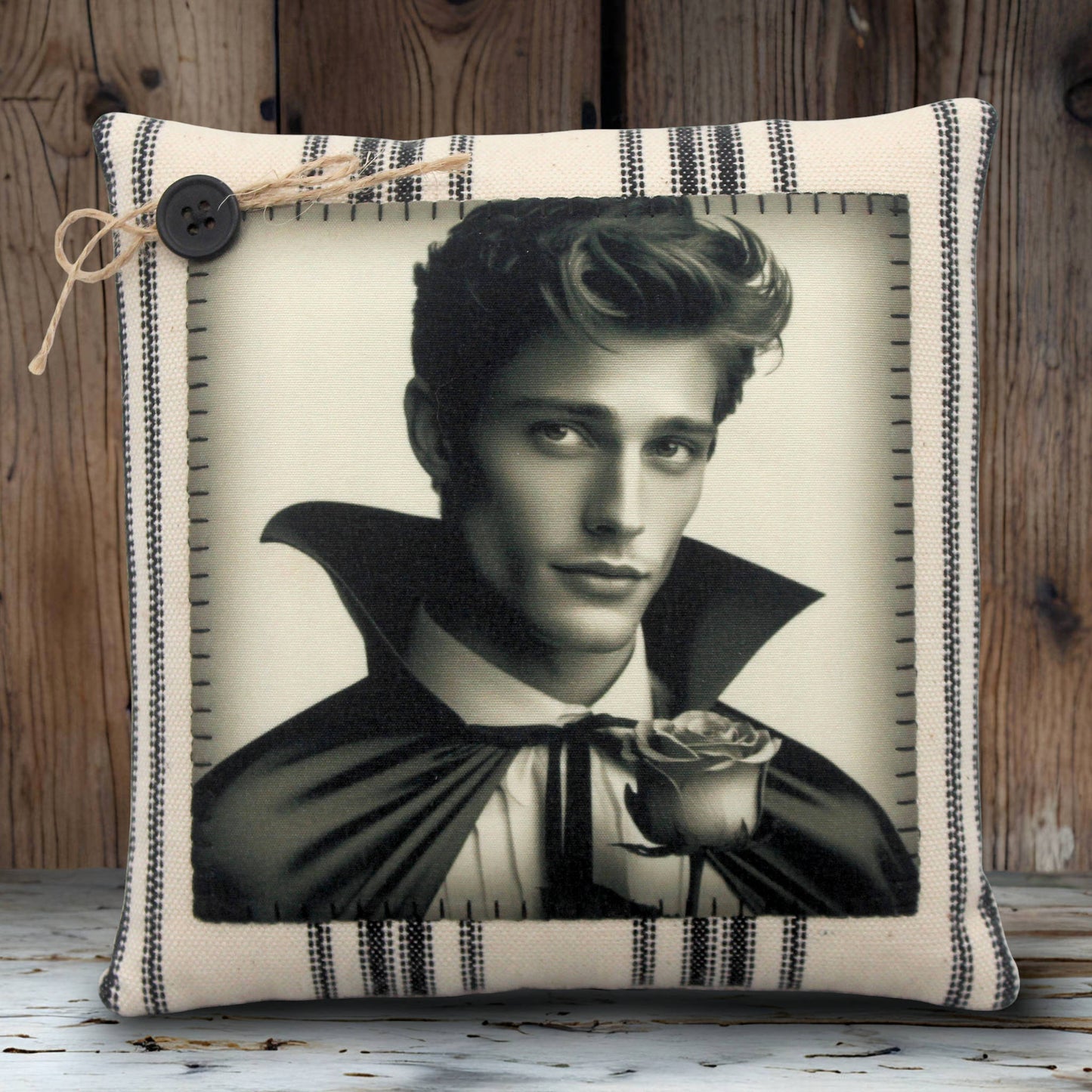 Decorative pillow with a black and white portrait of a handsome young vampire holding a rose on a striped background.
