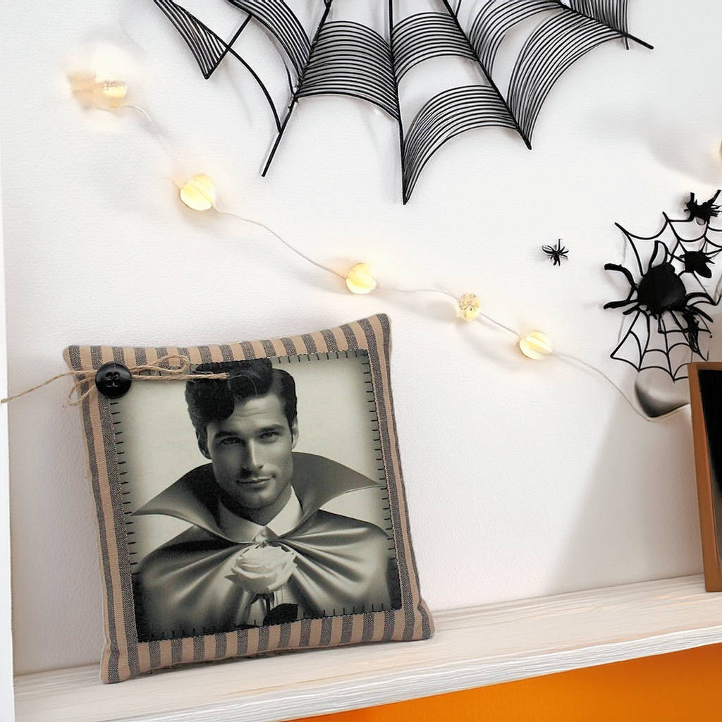 Decorative pillow with a handsome young vampire design on a shelf with Halloween decorations