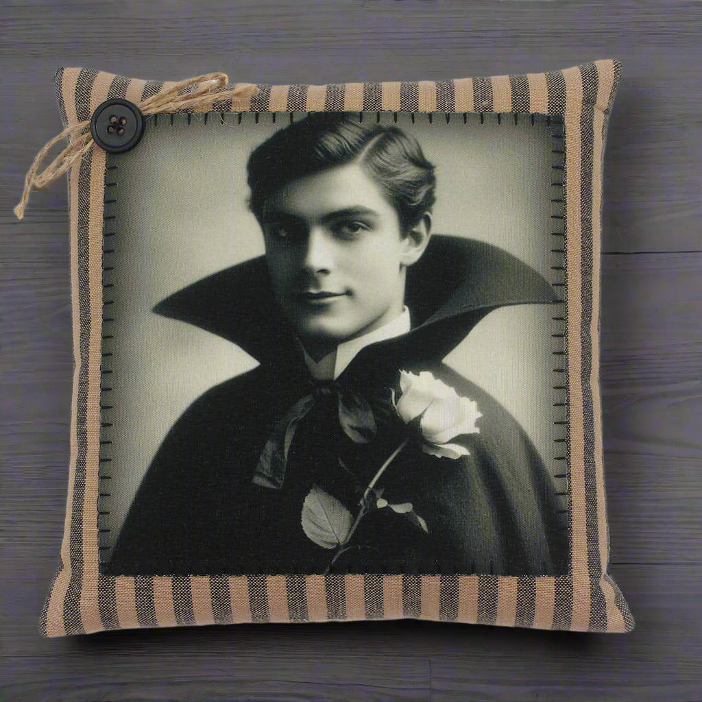 Decorative pillow with a vintage-style portrait of a handsome young vampire in a dark cape on a white background