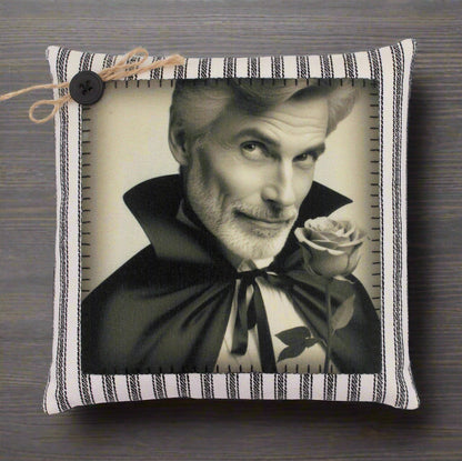 Pillow with a black and white portrait of a handsome vampire holding a rose, framed by a striped border.