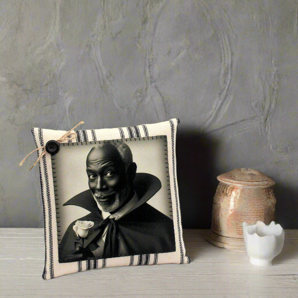 Decorative pillow with a black and white portrait of a vampire holding a rose on a light gray background
