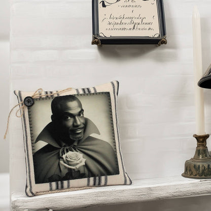 Decorative pillow with a black and white portrait of a vampire holding a rose on a shelf.