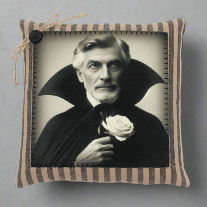 Pillow with a vintage-style portrait of a vampire in a dark robe holding a white rose, framed by striped fabric.