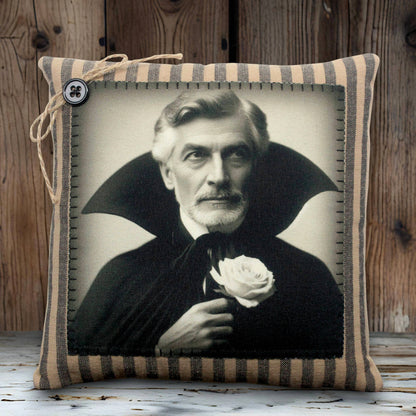 Pillow with a vintage-style portrait of a vampire in a dark robe holding a white rose, framed by striped fabric.