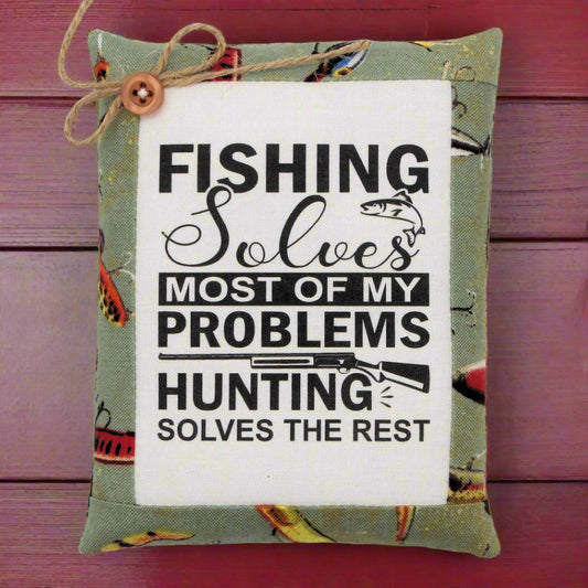 Decorative mini pillow sign with fishing and hunting quote on a wooden background