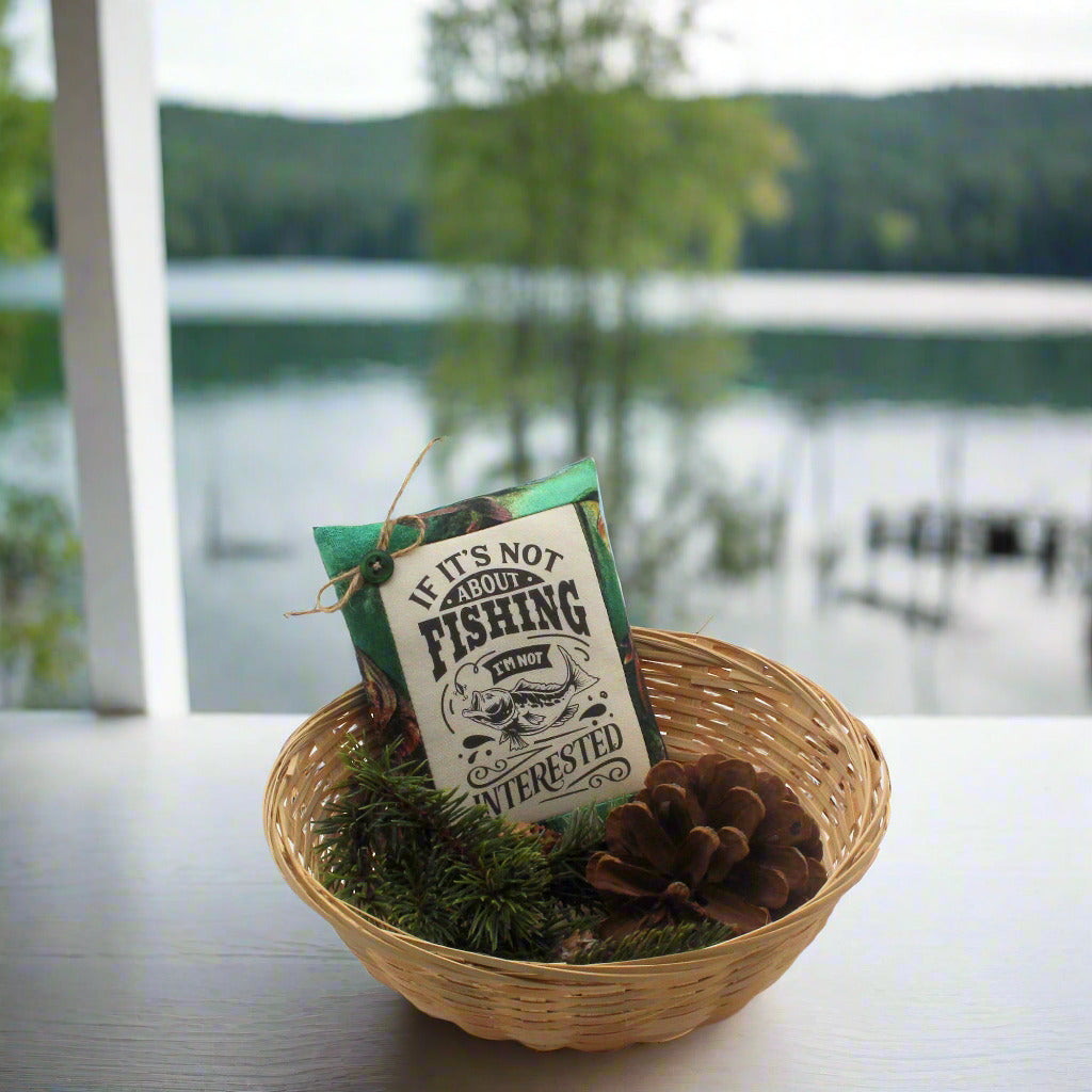 Decorative basket with a tag and pinecones in front of a lake view