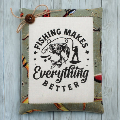 Decorative pillow tuck with fishing-themed text and graphics on a wooden surface