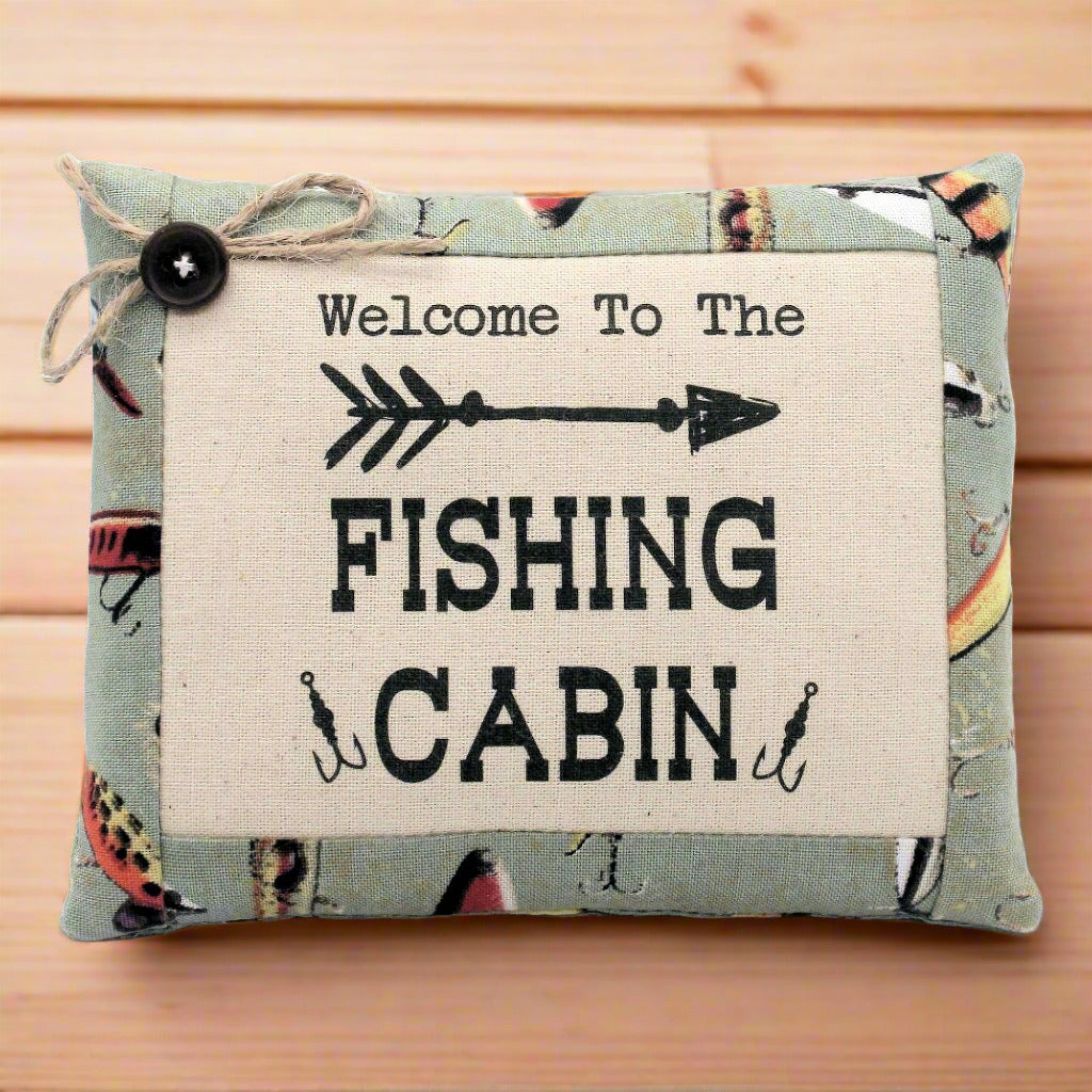 Decorative pillow tuck bowl filler with 'Welcome to the Fishing Cabin' text on a wooden background