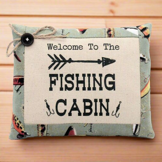 Decorative pillow tuck bowl filler with 'Welcome to the Fishing Cabin' text on a wooden background