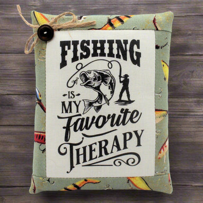 Decorative pillow tuck with fishing-themed text and graphics on a wooden background