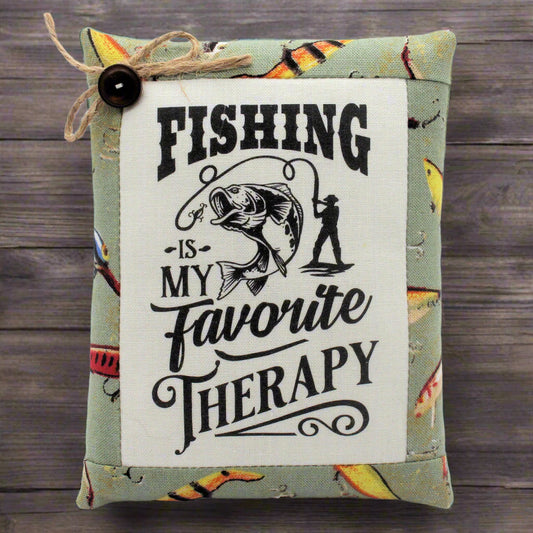Decorative pillow tuck with fishing-themed text and graphics on a wooden background