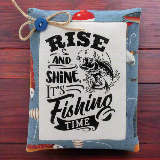Small fabric pillow with fishing-themed text and graphics on a white background