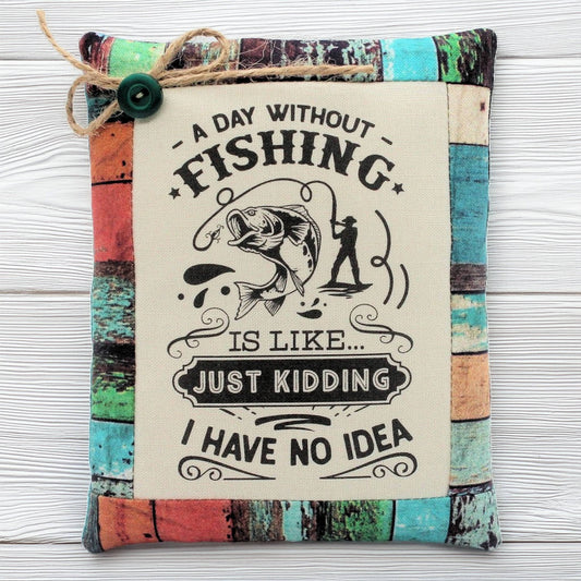 Decorative pillow tuck bowl filler with fishing-themed text and graphics on a wooden surface