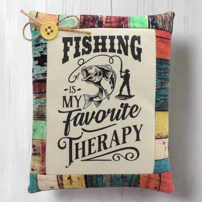 Decorative pillow tuck with fishing-themed text and graphics on a wooden background
